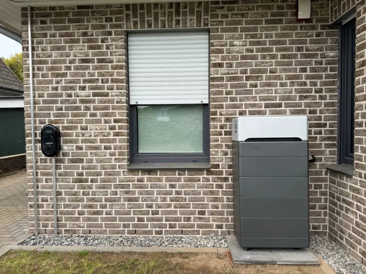 WEESS Batteriespeicher und Wallbox an Außenwand eines Einfamilienhauses installiert