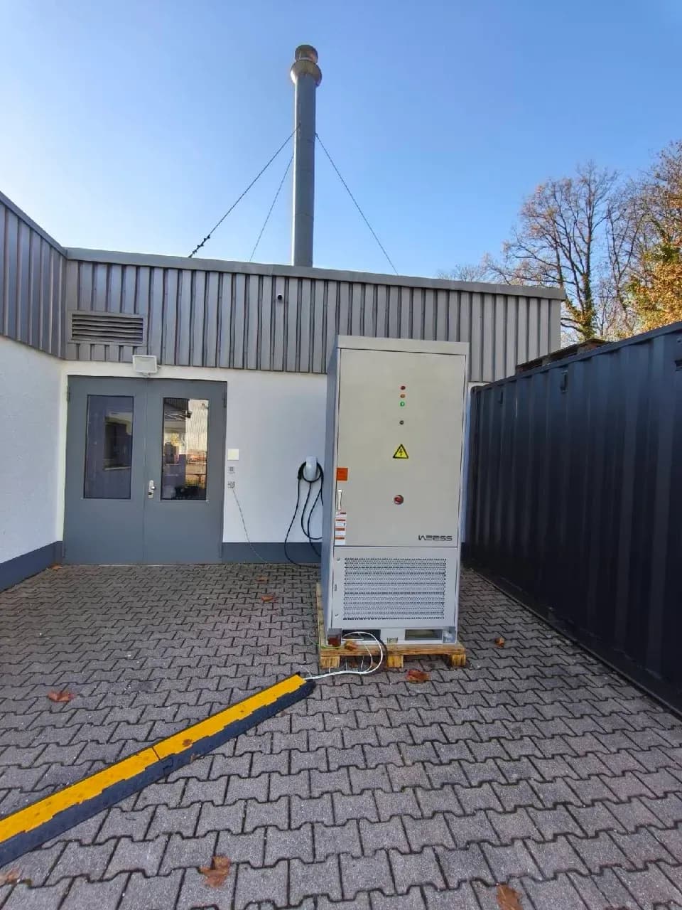 Außeninstallation eines WEESS I&C Energiespeichers neben Gewerbegebäude