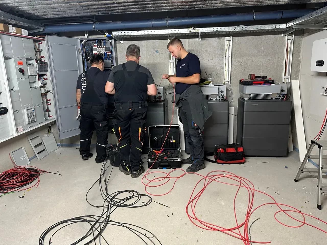 Techniker installieren WEESS Batteriespeicher und Energieverteilungssystem im Technikraum