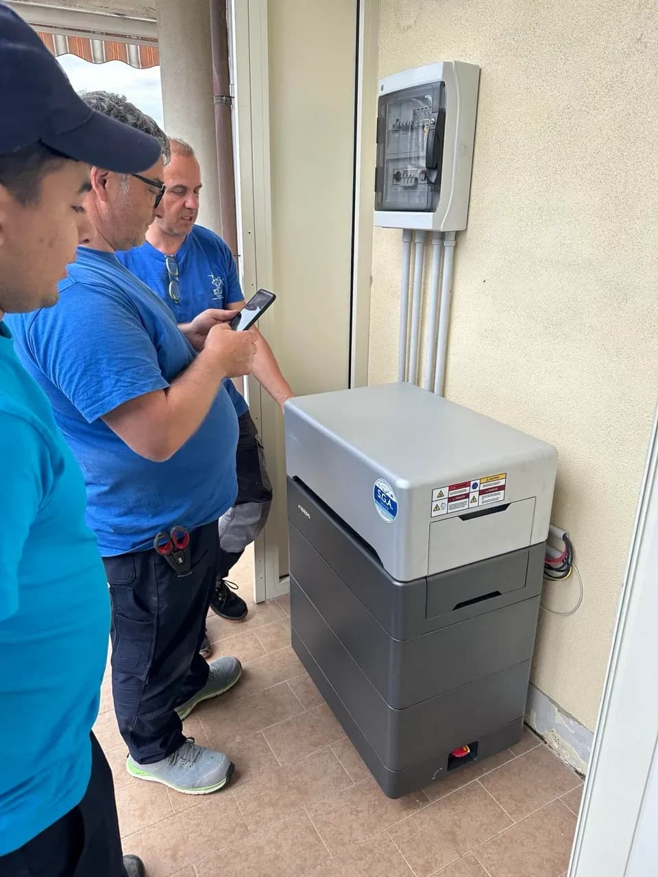 Techniker prüfen WEESS Energiespeicher und Anschlusskasten nach der Installation